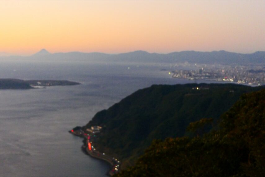 眼下に磯街道、遠くに鹿児島市街地や開聞岳